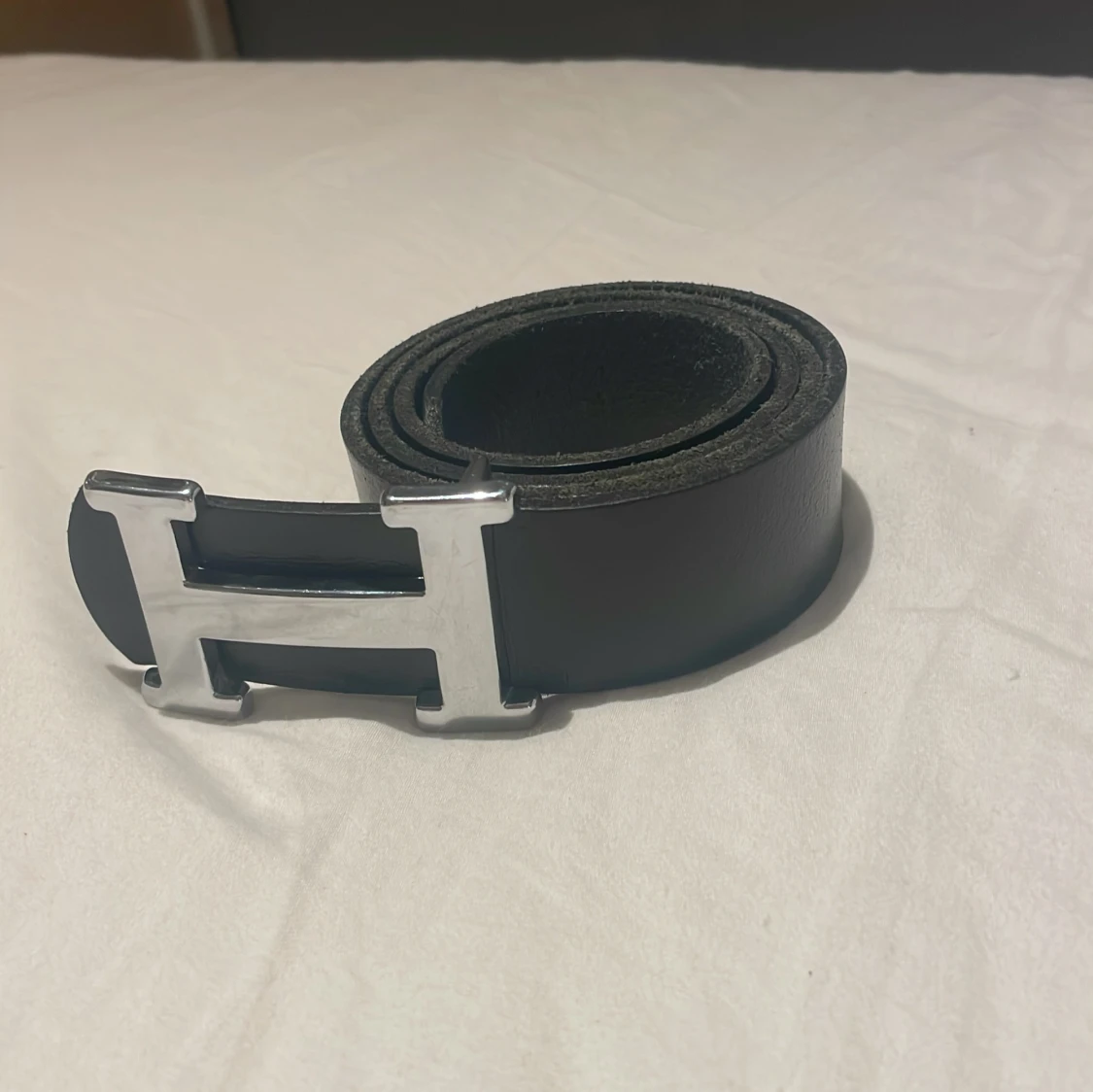 Svart läder bälte med ett silver H