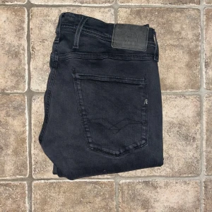 Replay Anbass jeans - Svarta Replay Anbass jeans i slim fit med klassisk femficksdesign. Jeansen har raka ben. Midja 40cm, längd 103cm. W31, L-storleken saknas men uppskappas till L32. Utgå från måtten. JAG SKICKAR EJ FLER BILDER NÄR JAG BÄR JEANSEN! för storleksguide hänvisar jag till måtten och för bättre inblick i passformen rekommenderar jag att googla på modellnamnet. Jeansen kan vara uppsydda utan att jag noterat det så kolla måtten noggrant :) s4