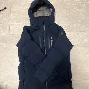 Sail Racing jacka - Säljer en mörkblå dunjacka från Sail Racing med huva och snygga logodetaljer på bröstet och ärmen. Jackan har inte använts särskilt länge och passar perfekt nu för vintertiderna! Tjena inte om du har frågor. Pris går att diskutera vid snabb affär 