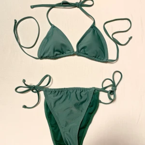 NA-KD grön bikini - Snygg grön bikini från NA-KD i trekantsmodell med justerbara knytband. Aldrig använd, endast lappar bortklippta. Den är jättefin på och passar perfekt till sommaren!