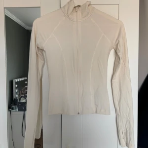 Beige ziptröja med lång ärm - Säljer denna creme färjade tränings jackan från Gina tricot!! Använd fåtal gånger och är därav i mycket bra skick. Tröjan har hål för tummarna i slutet av ärmarna. Kom privat om du undrar något❤️❤️