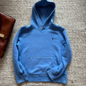 Ralph Lauren hooodie - Säljer denna ljusblå Ralph Lauren hoodie. Den är i mycket gott skick och har inga defekter. Säljer den för ett mycket överkomligt pris. Passar dig som är runt 160 cm. Kom med bud! 