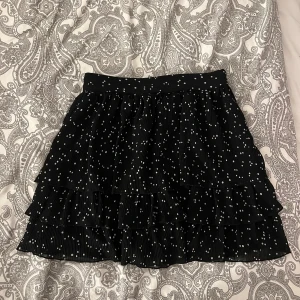 Prickig kjol - Svart kjol med vita prickar från Zara. Dragkedja på ena sidan. Storlek xs. Använt men fortfarande fint skick utan hål eller fläckar. Kjolen har även inbyggda shorts.  Kolla gärna in mina andra annonser, köp gärna bundle och lägg då gärna bud för paketpris😊