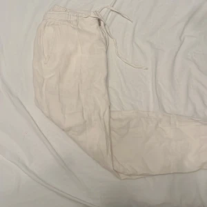 Vita linnebyxor i fint material - Nästan helt oanvända linnebyxor från Lindberg, storlek S. Riktigt skönt material, finns snörning fram till om man vill annars kan man lätt dölja dessa intill.