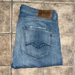 Replay jeans - Säljer ett par Replay Willbi jeans i ljusblå tvätt med slitningar och snyggt blekta detaljer. Klassisk femficksmodell med normal passform och raka ben. Midja 47cm, längd 112cm. JAG SKICKAR EJ FLER BILDER NÄR JAG BÄR JEANSEN! för storleksguide hänvisar jag till måtten och för bättre inblick i passformen rekommenderar jag att googla på modellnamnet. Jeansen kan vara uppsydda utan att jag noterat det så kolla måtten noggrant :) s4