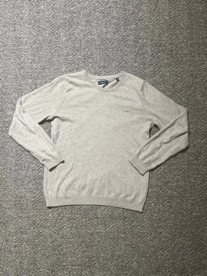 Grå stickad tröja från GANT - Snygg grå stickad tröja från GANT säljes. Tröjan är köpt för 600 kr men säljs för 199 kr. Den är i mycket bra skick då den har använts försiktigt, utan några skador – endast lätt nött, så gott som nyskick. Storlek dam XS (motsvarar ca 158) och passar lika bra på killar. Hör gärna av dig vid intresse!