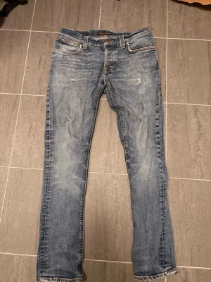 Nudie jeans - Snygga blå jeans från Nudie Jeans Co med klassisk femficksmodell och slitna detaljer. 