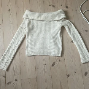Offshoulder ribbad tröja från H&M - Offshoulder tröja från H&M i ribbad, stickad kvalitet. Färgen är ljusbeige och modellen har långa ärmar och bred krage som vilar över axlarna. I strl s och bra passform. 