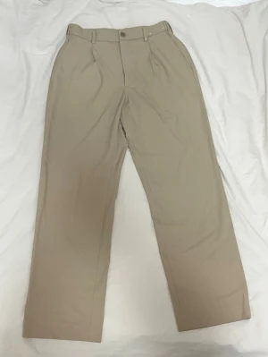 Beiga chinos Uniqlo wide leg - Pleated wide Trousers. Uniqlo. Strlk Small. Knappt använd. Otroligt bra kvalite 10/10 kondition. Passar även midja 30👍🏽
