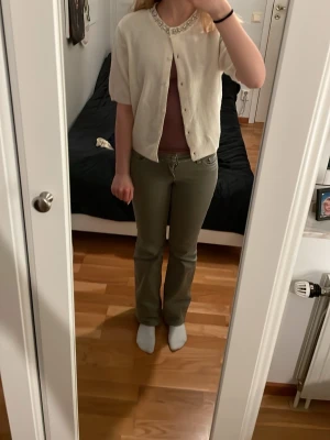 Vit kortärmad kofta - Snygg vit kofta med glittrande stenar i kragen och fina knappar. Den är kortärmad och har en lös passform, väldigt mjukt och skönt material. Perfekt att styla för en lite mindre basic look! Oanvänd💞