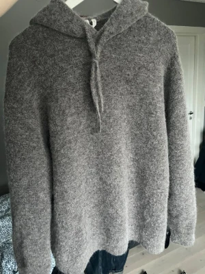 Grå stickad hoodie i ullmix - Tja! Säljer en riktigt snygg grå/brun, stickad hoodie. Märket är arket och tröjan är gjord av en alpacka- och ullblandning som gör den riktigt mjuk och skön! I princip nyskick. Skriv vid funderingar!