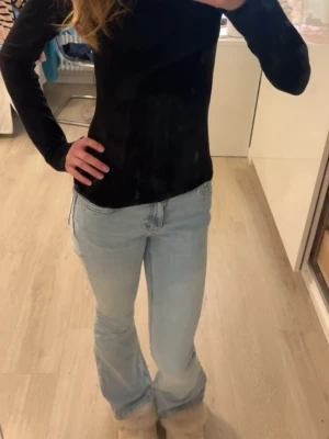 Ljusblå bootcut jeans - Säljer ett par ljusblå bootcut jeans med klassisk femficksdesign och normal passform. Jeansen har en snygg, enkel look och är perfekta för dig som gillar en avslappnad men trendig stil. Tillverkade i mjukt denimtyg för skön känsla.