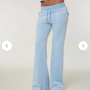 Ljusblå juicy byxor - Säljer ett par superfina ljusblå mjukisbyxor från Juicy Couture i deras klassiska velour-material. Modellen har flare/utsvängda ben och de snygga fickorna baktill med knappar.  Färg: Powder Blue / Ljusblå  Storlek: XS  Skick: Helt felfria och i nyskick. Inga skador eller slitage.  Detaljer: Justerbar midja med snörning och logga på sidan.  Perfekta för en trendig och bekväm look. Kom privat för frågor! ✨Nypris 1200