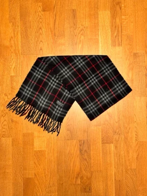 Mörkblå Burberry halsduk - Säljer är mörkblå halsduk från Burberry. Halsduken är gjord i 100% lamull och är i fint skick. Var inte rädd för några frågor. Pris diskuteras inte!