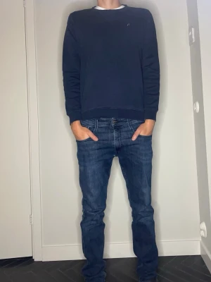 Replay sweatshirt  - En stilren mörkblå sweatshirt från Replay med rund halsringning och diskret logga på bröstet. Längd: 62cm Bredd: 48cm. Tröjan har långa ärmar och ribbade muddar vid ärmslut och nederkant. Perfekt för en avslappnad och snygg look. 