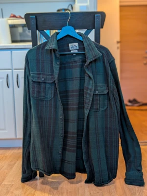 Grön rutig flanellskjorta – Roots (Lager 157) – stl XL – NY - Säljer en helt oanvänd rutig flanellskjorta från Roots (Lager 157). Lappen sitter kvar, aldrig använd. 🔸 Storlek: XL 🔸 Färg: mörkgrön/svart rutig 🔸 Tjock och mjuk flanell 🔸 Bröstfickor, klassisk workwear-stil 🔸 Perfekt till höst/vinter Pris: 250 kr Kan skickas mot frakt eller hämtas enligt överenskommelse. Hör av dig vid intresse!