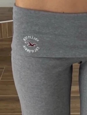 Grå leggings från Hollister!!☕️🤞🏽 - Snygga grå leggings från Hollister med bred midja och logga framtill. Mjukt och stretchigt material som sitter tight och bekvämt. Perfekta till både chill och träning, med klassisk Hollister California-brodyr på höften. super populära!! Går ej å få tag på längre)🫰🏽Passsr mig som är 165 ish, passade även mig när ja var 163
