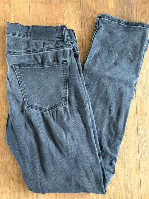 Grå jeans från J.Lindeberg - Snygga grå jeans från J.Lindeberg med klassisk femficksmodell och diskret JL-detalj på myntfickan.  Ny pris 1500kr ca, knappt använda därav mycket bra skick. W32 L32