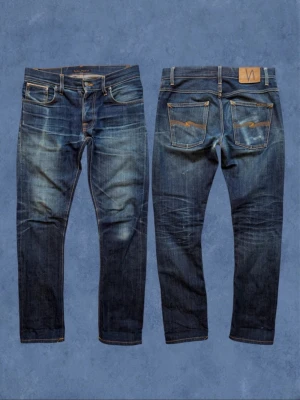 Nudie Dry Japan Selvedge - Ett par nudie jeans i materialet ”dry japan selvedge” som fått en stört snygg fading! Modell ”Grim Tim”. Väldigt fint skick, skriv vid minsta lilla fundering! 😁🙌