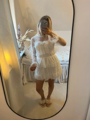 Vit volangklänning med spetsdetaljer - Söt vit kortklänning med volanger. har klippt av den själv då ja tyckte den va för lång, inget som syns. använd en gång på midsommar. 