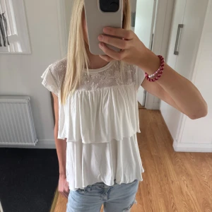 Vit blus med spets från Kappahl -  vit blus från Kappahl med volanger och broderad spets upptill💕💕sitter som en xs💕💕
