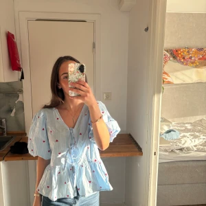 Blå blus med hjärtan och puffärm - Säljer en ljusblå blus med vita ränder och små röda hjärtan. Från Pernilla Wahlgren🥰xs/s