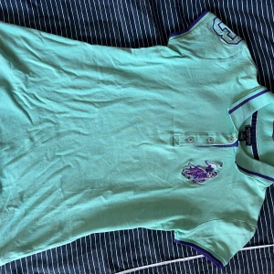 Mintgrön pikétröja från U.S. Polo Assn. - Snygg mintgrön pikétröja från U.S. Polo Assn. med lila broderad logga på bröstet och lila detaljer på krage och ärmslut. Storlek xs. Säljer då den inte kommer till användning. 
