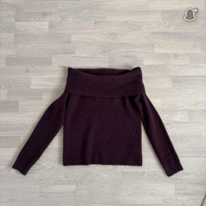Vinröd stickad tröja - Supermysig vinröd stickad tröja från Gina Tricot med bred ribbad offshoulder-krage. Långärmad modell som sitter snyggt över axlarna och har en lite loose passform. Perfekt för dig som gillar en trendig och bekväm stil.