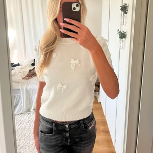 Vit stickad topp med rosetter - Säljer denna superfina vita topp från Missay med söta rosetter över hela framsidan💗 Är i storlek S och fint skick! Skriv vid funderingar 🙌🏻
