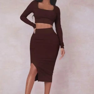 Mörkbrun ribbad långkjol med matchande långärmad topp  - Säljer en mörkbrun långkjol med matchande topp i ribbad struktur och snygg slits på sidan. Kjolen har en tight passform och är gjord i mjukt bomullsmaterial. 