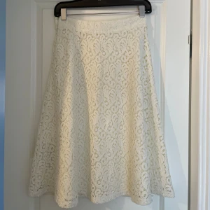 Vit spetskjol från Massimo Dutti - Superfin vit långkjol från Massimo Dutti i storlek 38. Kjolen har ett vackert spetsmönster med snygga detaljer och är fodrad under. Perfekt för dig som gillar en romantisk och elegant stil. Använt endast en gång! 