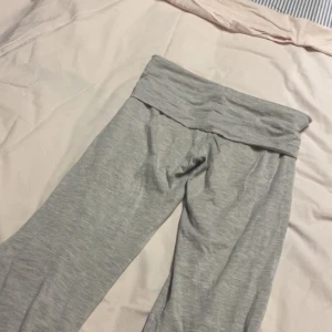 Grå mjukisbyxor med bred midja - Superbekväma grå mjukisbyxor med bred, vikt midja och raka, lite utsvängda ben. Perfekta för chill eller träning. Tillverkade i mjukt bomullsmaterial som känns skönt mot huden.