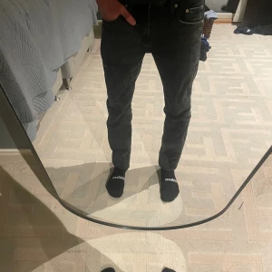 Svarta slim jeans från lager 157 - Svarta jeans från Lager 157 i slim fit med klassisk femficksdesign. Jeansen har en något tvättad look och små slitningar på benen för en cool, avslappnad stil. Tillverkade i stretchig denim som sitter hyfsat tajt längs benen och midjan. Fint skick Storlek 29/31 ungefär