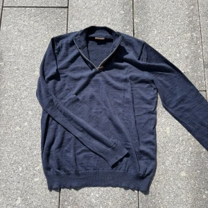 Marinblå halvzip-tröja Stenströms - Snygg marinblå stickad tröja från Stenströms med half zip och ribbad krage. Perfekt för lager-på-lager och chill stil. Långärmad och i mjukt material som känns skönt mot huden. Passar dig som gillar klassisk men avslappnad look.