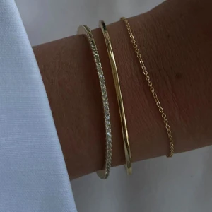 Guldpläterat armband med zirkoner - 18k guldpläterad mässing med 1 mm vita kubiska zirkoner längs hela ovansidan. Armbandet är stelt och öppet i modellen, vilket gör det enkelt att ta på och av. Knappt använd! Kostar 599 nypris. Matchande armband och dustbac skickas med vid köp  ❣️