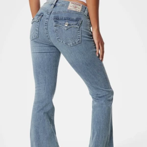 Bootcut jeans från True Religion - Snygga ljusblå bootcut jeans från True Religion i modell Becca med klassiska fickor och dekorativa sömmar bak. Jeansen har normal passform, med medelhög midja och bootcut passform. Storlek 24/30