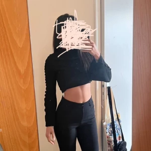 Svarta bootcut kostymbyxor - Svarta byxor som är bootcut och klassisk passform. Byxorna har en enkel design utan synliga detaljer och är perfekta för en stilren look. Materialet känns mjukt och stretchigt, vilket gör dem bekväma att bära hela dagen.