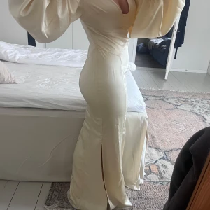 Adoore klänning  - Jättefin Adoore klänning, bara använd 1 gång. Figursydd i snyggt sidenimiterat material❣️storlek 40 men passar mig som vanligtvis har 36/38, ljusgul/champangefärgad 