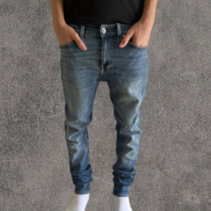Blå slim jeans från Tiger of Sweden, 29/32 - Snygga blå jeans från Tiger of Sweden i modellen Evolve. Jeansen har klassisk femficksdesign, normal passform och raka ben. Tillverkade i Italien av slitstarkt denimtyg. Perfekta för dig som gillar stilrena och tidlösa jeans.