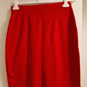 Röd pennkjol från Tatch - Knälång röd kjol från Tatch i mjukt bomullstyg och modal. Ej använd. Passar även en som har medium.