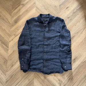 Mörkblå linneskjorta från Massimo Dutti - Skjorta av 100% linne från Massimo Dutti. Skjortan är i 9/10 skick och är bara använd sparsamt. Nypriset låg på 1000 kr. Hör av er om ni har frågor!.