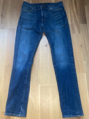 Blå skinny jeans från Jack&Jones - Säljer ett par klassiska blå skinny jeans. Jeansen har fem fickor, normal midja och snygga slitningar framtill för en avslappnad look. Perfekta till sneakers eller boots och passar till det mesta i garderoben. 😊