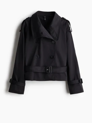 Svart trenchcoat med bälte - Snygg svart kort trenchcoat med dubbelknäppning, bred krage och bälte i midjan. Jackan har även spännen vid ärmsluten och axelklaffar för extra detaljerad look. Perfekt för dig som gillar klassisk men modern stil.