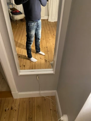 Blå slim jeans från Jack & Jones - Säljer ett par blå slim fit jeans från Jack & Jones, modell Glenn. Jeansen har snygga tvättade detaljer, klassisk femficksdesign och gul kontrastsöm. Passformen är slim och materialet är mjukt denim för en bekväm känsla. Kostar 800 nya och inte använda så så mycket.