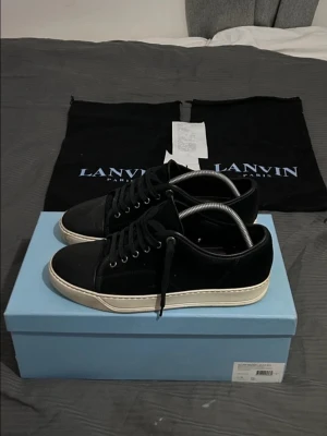 Svarta sneakers från Lanvin - Säljer ett par stilrena svarta sneakers från Lanvin. Låda, kvitto, dustbags och extra snören medföljer.