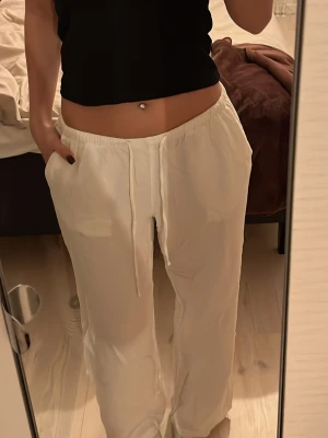 Vita linnebyxor från Gina Tricot - Säljer ett par vita linnebyxor från Gina Tricot i storlek M. Byxorna har dragsko i midjan, raka ben och sidofickor. Perfekta för chill dagar eller när du vill ha en avslappnad look. Materialet är mjukt och luftigt linne.