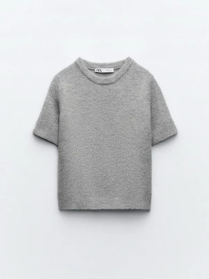 Grå stickad kortärmad tröja Zara - Mysig grå stickad tröja från Zara med korta ärmar och rund hals. Ribbstickade kanter vid ärmslut och nederkant.