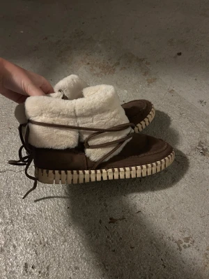 Bruna boots från Ilse Jacobsen - Mysiga bruna boots från Ilse Jacobsen med beige foder i pälsimitation och grov sula. Skorna sopar vinterlooken med snörning runt skaftet och mjukt mockamaterial. Perfekta för kalla dagar och riktigt snygga till jeans eller leggings. Det är storlek 42 men passar även 41 och 40 då det är en ganska tjock pälsula🥰