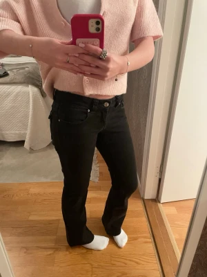 Svarta bootcut low waist jeans  - Säljer ett par svarta bootcut low waist jeans från Gina tricot i storlek 36, byxorna är kolsvarta med snygga fickor bak och har en mycket snygg passform och de är även stretchiga i materialet. Byxorna har varit använda med inga skador eller fläckar, passar till allt! Säljer de pga för korta💗