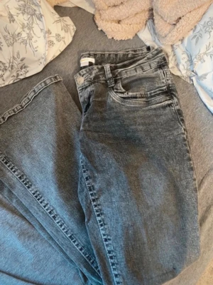 Lågmidjade utsvängda jeans från GINA 14+ - Från gina14+ Jeansen är med hög stretch och lågmidjade Detaljer på fickorna samt att det är olika nyanser av grå Knappt använda men säljs eftersom jag tyckte de var ”för lågmidjade” för mig Skriv vid frågor eller fler bilder🫶🏻💕
